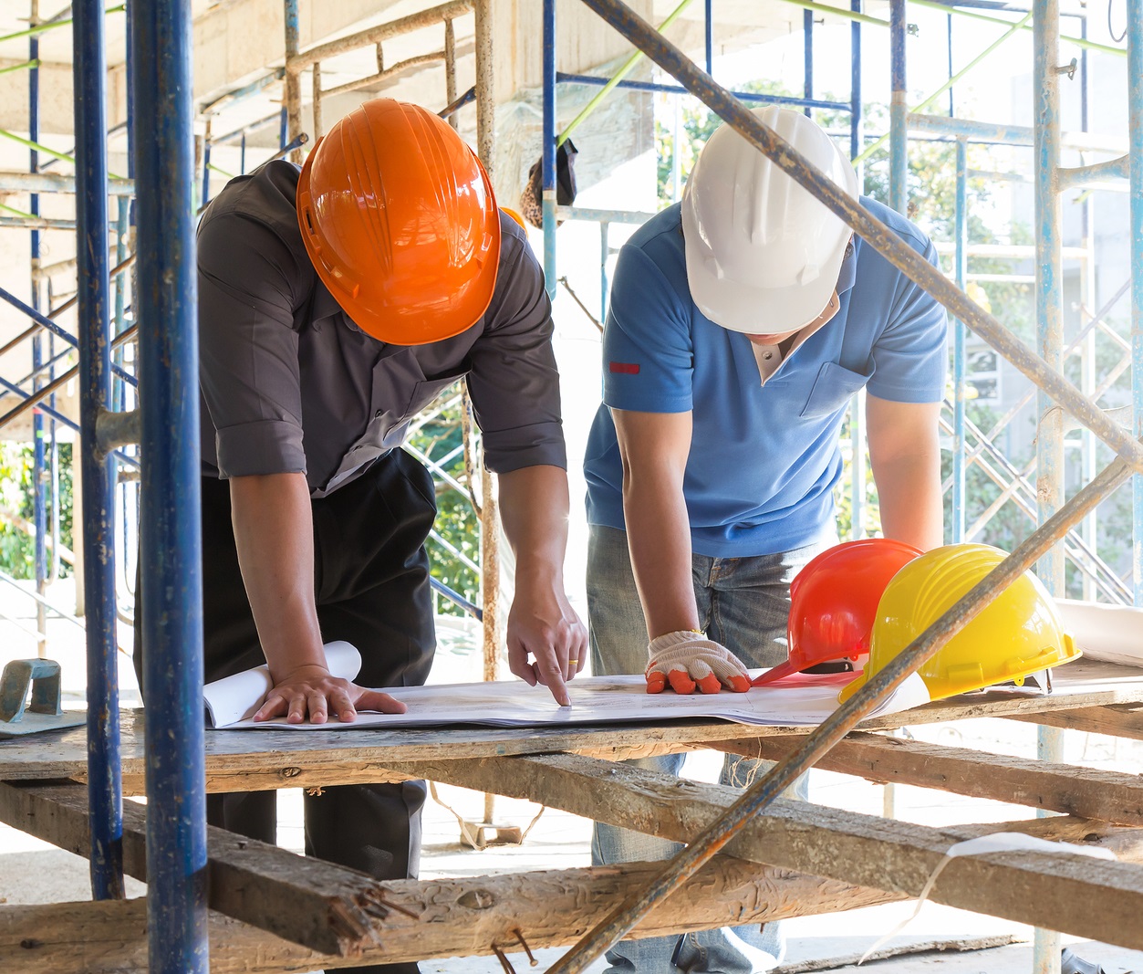 two men at construction site reviewing plans